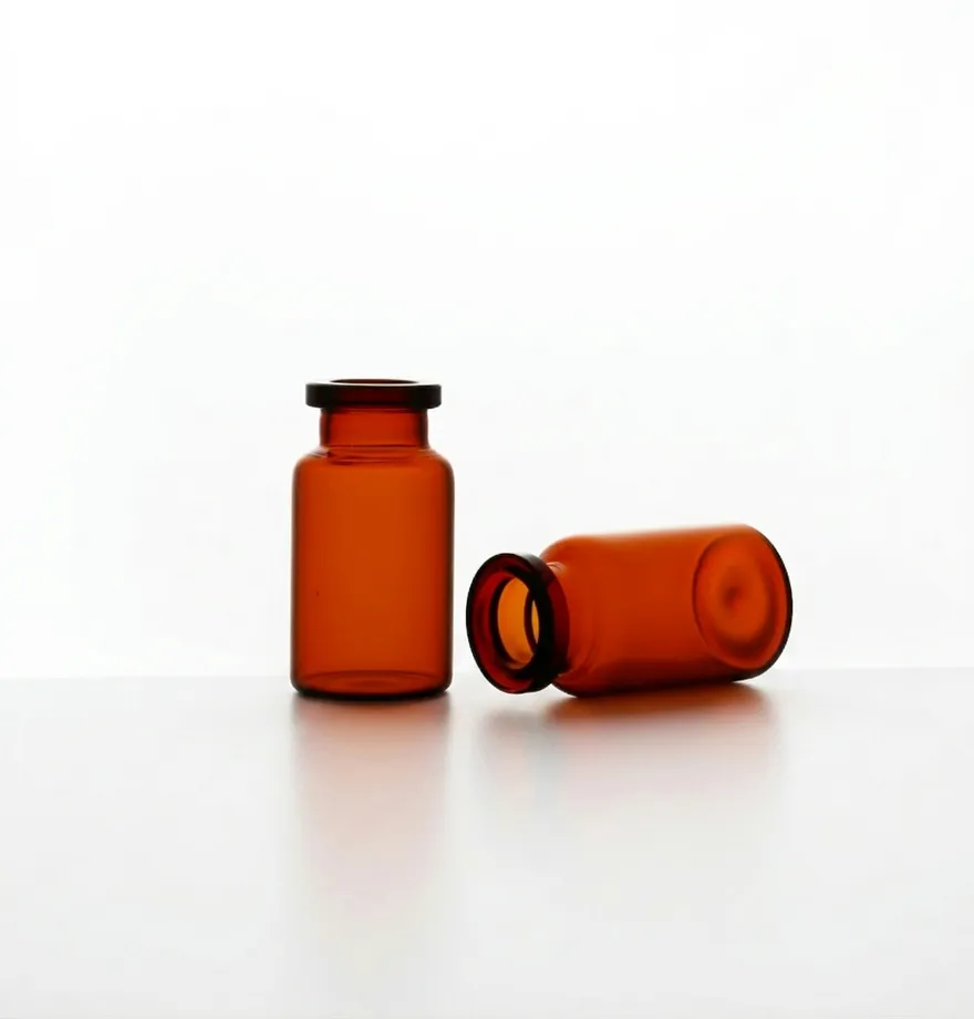 Two amber borosilicate glass vials, one upright and one lying on its side