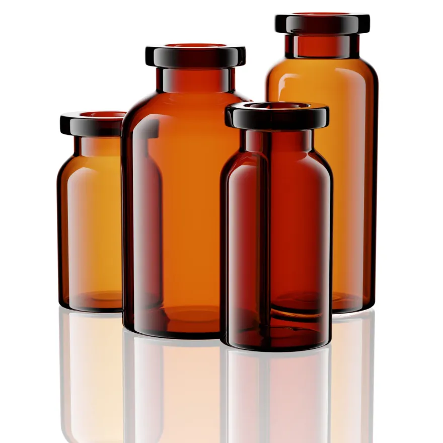 Four amber glass vials in assorted sizes arranged on a white background